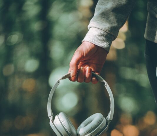 “작은 변화가 만드는 큰 차이, 일상 속 스트레스 관리법” a person holding a pair of headphones in their hand