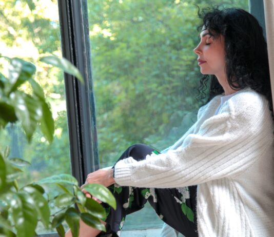 “매일 조금씩, 뇌건강 챙기는 작은 습관이 인생 바꾼다” a woman sitting on a window sill looking out the window
