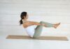 필라테스, 바쁜 일상 속 건강 지킴이로 자리매김하다 Woman in boat pose on yoga mat