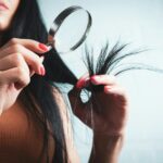 변화하는 헤어 건강 관리 트렌드, 일상 속에서 실천하는 방법 Woman examining split ends of hair with magnifying glass