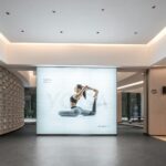 바쁜 일상 속 ‘필라테스’, 척추 건강과 마음 균형을 동시에 Woman in yoga pose on illuminated display