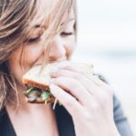 ‘나를 돌보는 작은 습관’… 웰니스 문화가 우리 삶에 스며든다 woman eating sandwich